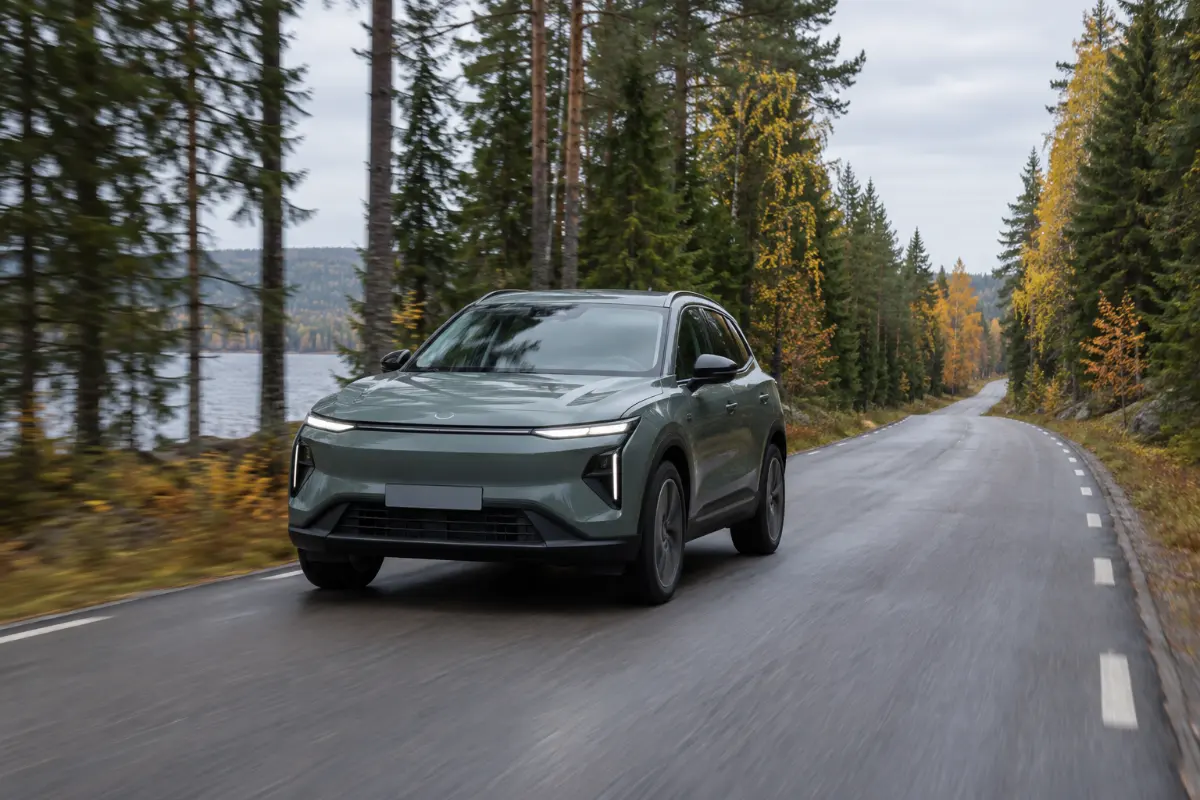 Kompakt eldriven SUV på en landsväg genom svensk barrskog