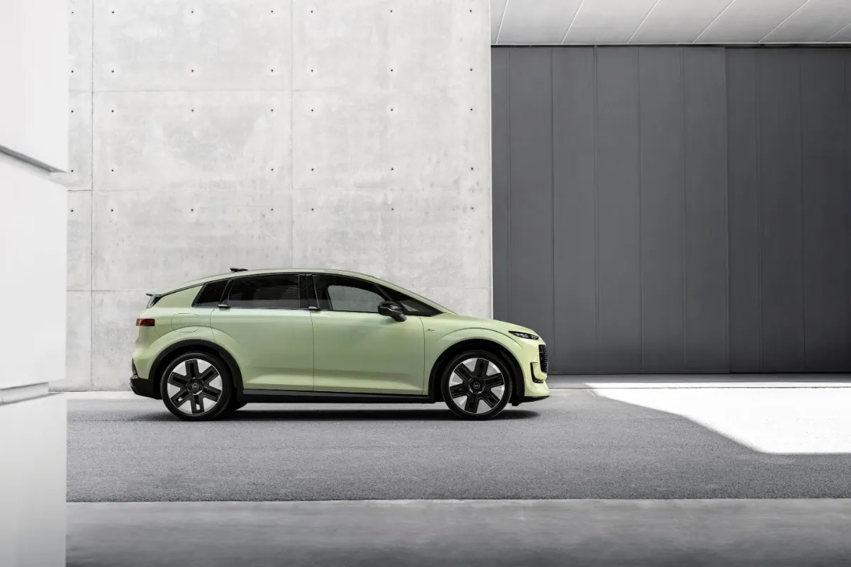 Ljusgrön Audi A2 e-tron från sidan framför en betongvägg